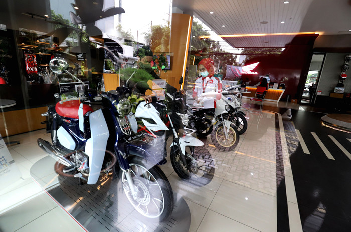 Pekerja melayani calon pembeli sepeda motor di salah satu showroom di Jakarta, Senin (29/3/2021).