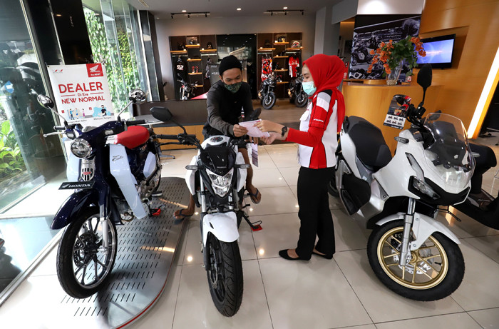 Pekerja melayani calon pembeli sepeda motor di salah satu showroom di Jakarta, Senin (29/3/2021).