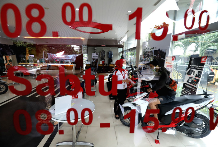 Pekerja melayani calon pembeli sepeda motor di salah satu showroom di Jakarta, Senin (29/3/2021).