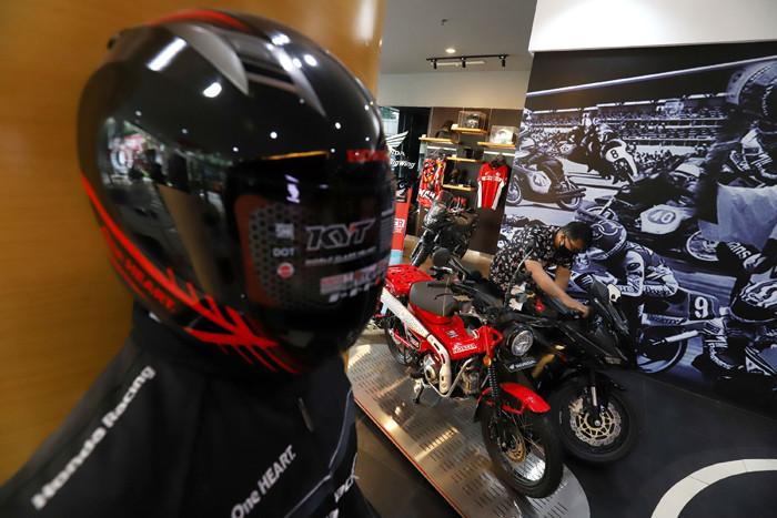 Pekerja melayani calon pembeli sepeda motor di salah satu showroom di Jakarta, Senin (29/3/2021).