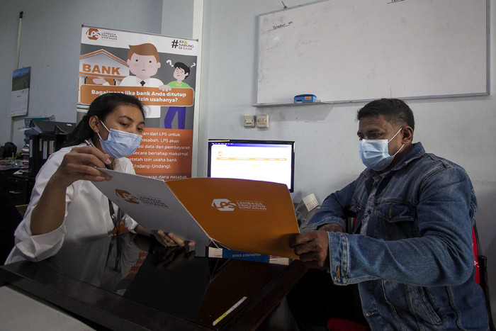 Petugas Lembaga Penjamin Simpanan (LPS) melayani nasabah di Bank Perkreditan Rakyat (BPR) Arthaprima Danajasa, Kota Bekasi, Jawa Barat, Selasa (30/3/2021).