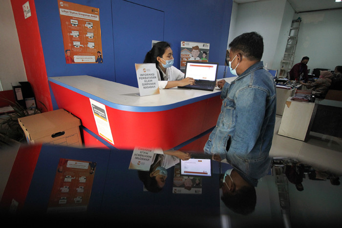 Petugas Lembaga Penjamin Simpanan (LPS) melayani nasabah di Bank Perkreditan Rakyat (BPR) Arthaprima Danajasa, Kota Bekasi, Jawa Barat, Selasa (30/3/2021).