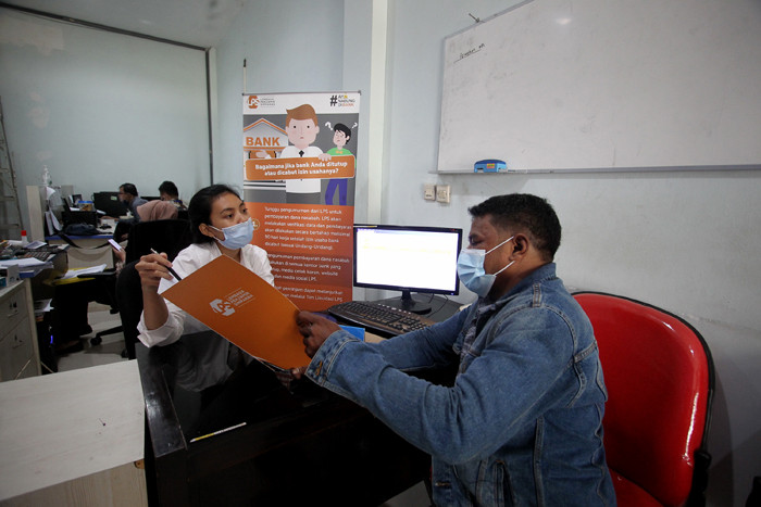Petugas Lembaga Penjamin Simpanan (LPS) melayani nasabah di Bank Perkreditan Rakyat (BPR) Arthaprima Danajasa, Kota Bekasi, Jawa Barat, Selasa (30/3/2021).