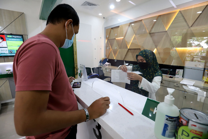 Karyawan melayani nasabah di Kantor Cabang Pegadaian di kawasan, Jakarta Pusat, Rabu (31/3/2021).