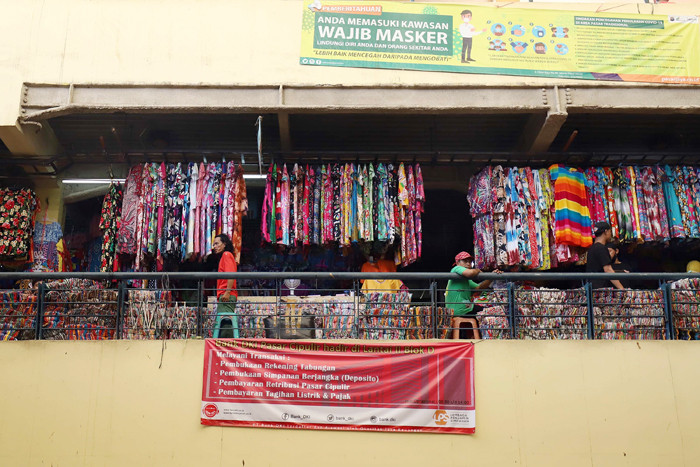 Pedagang mengemas pakaian jadi yang laku terjual di Pusat Grosir Pasar Cipulir, Jakarta, Rabu (31/3/2021).