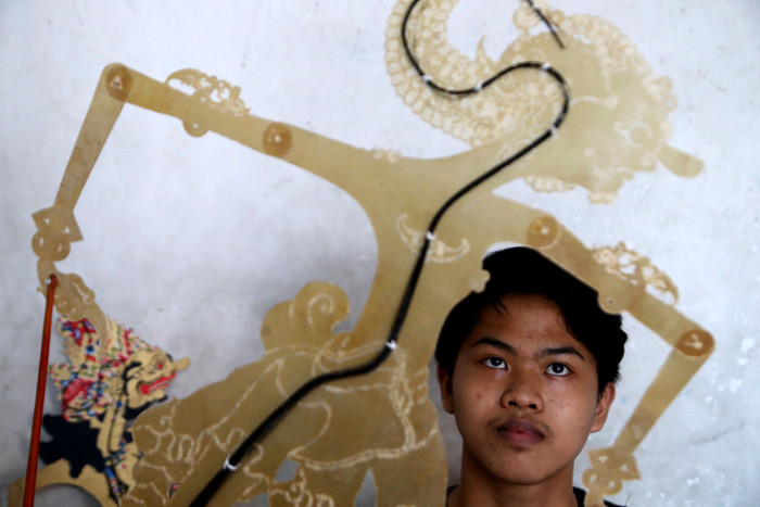 Perajin wayang Ahmad Maiyo Satria Tama (16) menyelesaikan pembuatan dan perbaikan wayang di Surabaya, Jawa Timur, Rabu (31/3/2021).