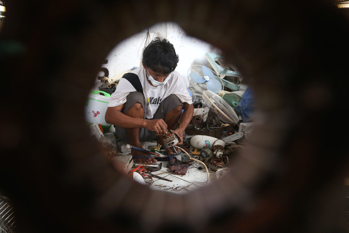 Tukang servis kipas angin, Musyafak menyelesaikan perbaikan kipas angin di Pasar Loak Gembong Surabaya, Jawa Timur, Kamis (1/4/2021).