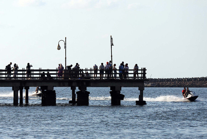 Pengunjung bermain di Pantai Indah Ancol di Jakarta, Jumat (2/4/2021).