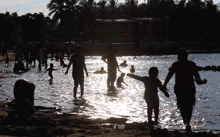 Pengunjung bermain di Pantai Indah Ancol di Jakarta, Jumat (2/4/2021).