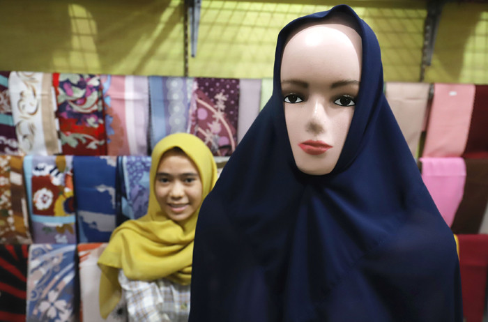 Penjual merapikan hijab di toko busana muslim di kawasan Pondok Melati, Kota Bekasi, Jawa Barat, Jumat (2/4/2021).