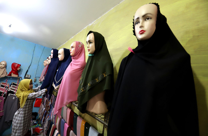 Penjual merapikan hijab di toko busana muslim di kawasan Pondok Melati, Kota Bekasi, Jawa Barat, Jumat (2/4/2021).