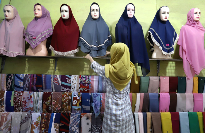 Penjual merapikan hijab di toko busana muslim di kawasan Pondok Melati, Kota Bekasi, Jawa Barat, Jumat (2/4/2021).