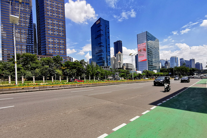 Pengendara melintas di Jalan Jenderal Sudirman, Jakarta, Jumat (2/4/2021).
