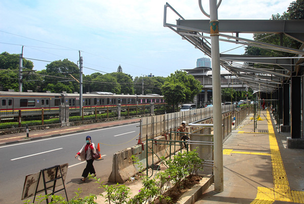 Pekerja menyelesaikan pembuatan halte di Stasiun Palmerah, Jakarta Pusat, Senin (5/4/2021).
