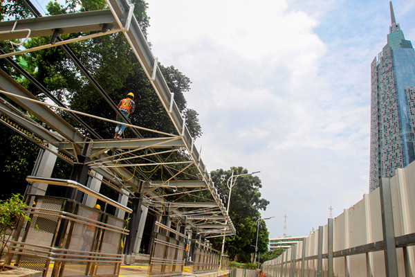 Pekerja menyelesaikan pembuatan halte di Stasiun Palmerah, Jakarta Pusat, Senin (5/4/2021).