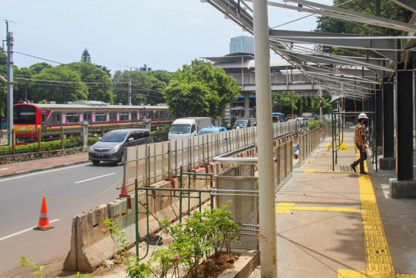 Pekerja menyelesaikan pembuatan halte di Stasiun Palmerah, Jakarta Pusat, Senin (5/4/2021).