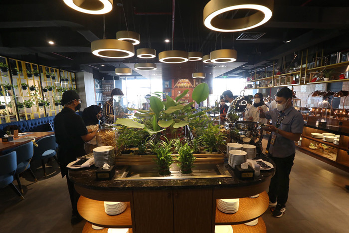 Waiter menyiapkan ragam menu tradisional di Grand Kitchen Royal Tulip Darmo, Surabaya, Jawa Timur, Rabu (7/4/2021).