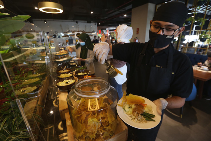 Waiter menyiapkan ragam menu tradisional di Grand Kitchen Royal Tulip Darmo, Surabaya, Jawa Timur, Rabu (7/4/2021).