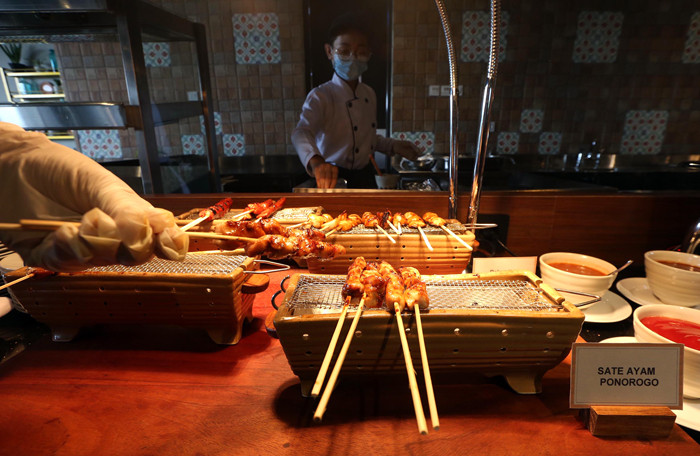 Waiter menyiapkan ragam menu tradisional di Grand Kitchen Royal Tulip Darmo, Surabaya, Jawa Timur, Rabu (7/4/2021).