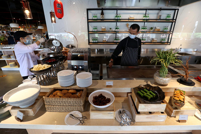 Waiter menyiapkan ragam menu tradisional di Grand Kitchen Royal Tulip Darmo, Surabaya, Jawa Timur, Rabu (7/4/2021).
