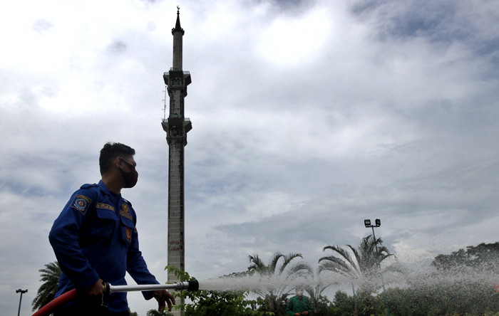 Petugas pemadam kebakaran tengah menyemprotkan cairan disinfektan di Masjid Al Markaz Al Islami, Makassar, Sulawesi Selatan, Kamis (8/4/2021).