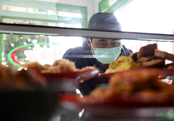Penjual melayani pembeli di Warteg Kharisma di kawasan Jakarta Timur, Kamis (8/4/2021).