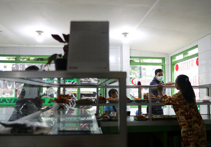 Penjual melayani pembeli di Warteg Kharisma di kawasan Jakarta Timur, Kamis (8/4/2021).