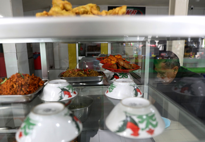 Penjual melayani pembeli di Warteg Kharisma di kawasan Jakarta Timur, Kamis (8/4/2021).