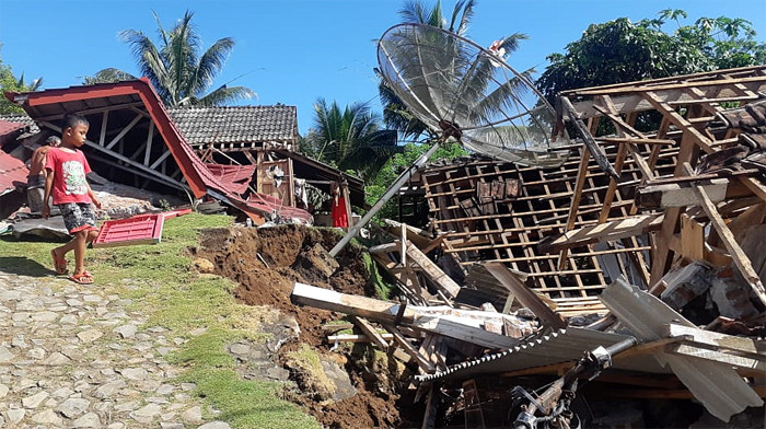 Warga melintas di dekat masjid yang hancur akibat terdampak gempa Malang di Dusun Iburaja, Desa Kaliuling, Kabupaten Lumajang, Jawa Timur, Minggu (11/4/2021).