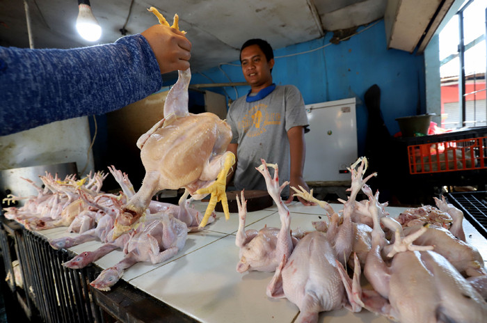 Pedagang daging ayam melayani pembeli di Pasar Kecapi, Kota Bekasi, Jawa Barat, Senin (12/4/2021).