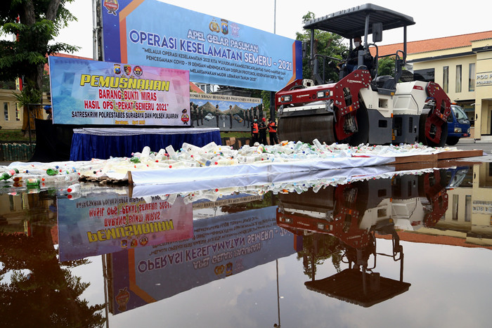 Polisi memusnahkan ribuan barang bukti minuman keras pada hari pertama puasa Ramadan, di halaman Mapolrestabes Surabaya, Jawa Timur, Selasa (13/4/2021).