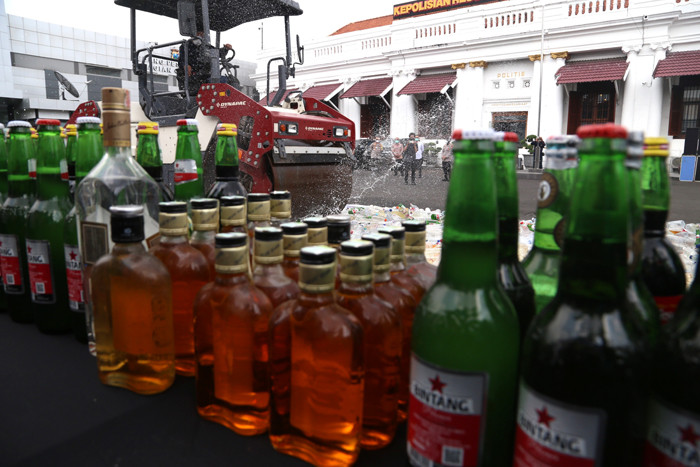 Polisi memusnahkan ribuan barang bukti minuman keras pada hari pertama puasa Ramadan, di halaman Mapolrestabes Surabaya, Jawa Timur, Selasa (13/4/2021).