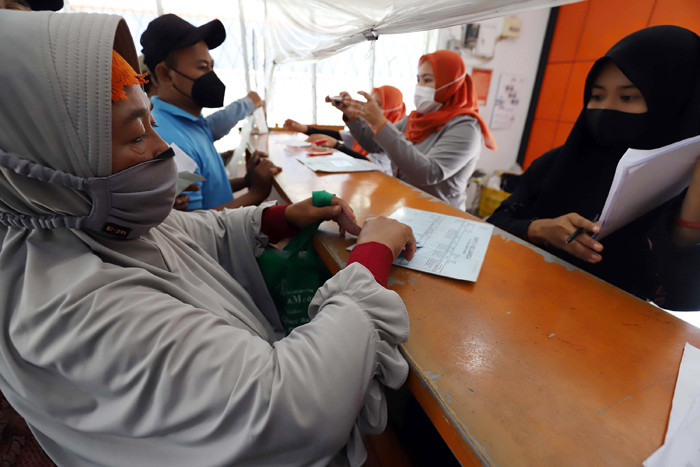 Warga mengantre saat pengambilan Bantuan Sosial Tunai (BST) di Kantor Pos di kawasan Parung, Bogor, Jawa Barat, Rabu (14/4/2021).