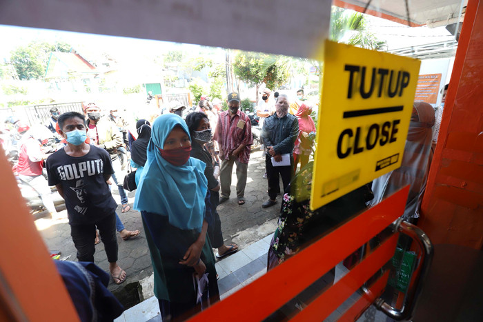 Warga mengantre saat pengambilan Bantuan Sosial Tunai (BST) di Kantor Pos di kawasan Parung, Bogor, Jawa Barat, Rabu (14/4/2021).
