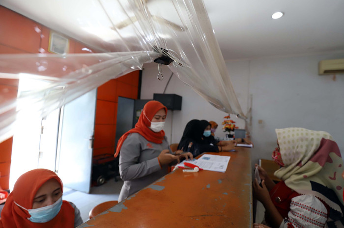 Warga mengantre saat pengambilan Bantuan Sosial Tunai (BST) di Kantor Pos di kawasan Parung, Bogor, Jawa Barat, Rabu (14/4/2021).