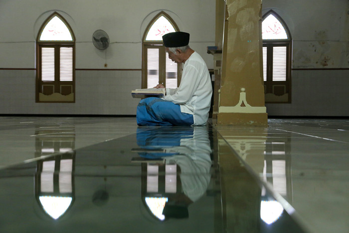 Umat Muslim membaca Alquran di Masjid Peneleh Surabaya, Jawa Timur, Rabu (14/4/2021).