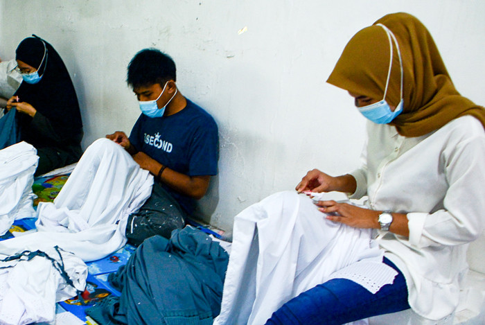 Pekerja menyelesaikan pembuatan mukena di pabrik busana muslim Siti Khadijah di kawasan Depok, Jawa Barat, Selasa (13/4/2021).