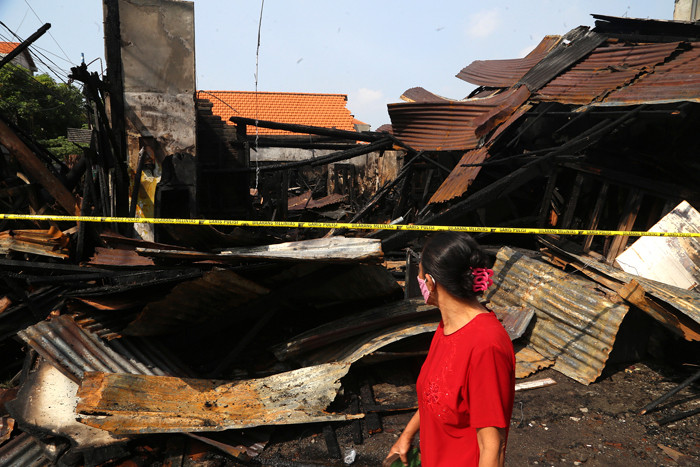 Petugas PLN memperbaiki jaringan listrik yang terputus pasca kebakaran bengkel mebel di Jalan Semolowaru, Surabaya, Kamis (15/4/2021).
