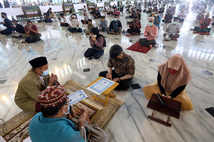Dua mualaf mengikuti proses masuk Islam dengan mengucapkan dua kalimat syahadat usai Shalat Jumat di Masjid Al-Akbar Surabaya, Jawa Timur, Jumat (16/4/2021)