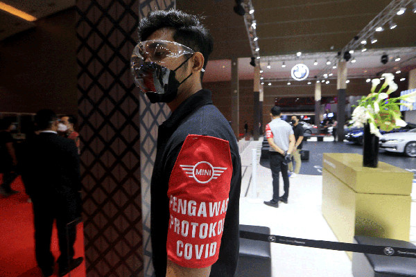 Satgas Covid 19 berpatroli mengelilingi booth pameran IIMS Hybrid 2021 mengingatkan pengunjung untuk selalu menerapkan prokes di Jakarta, Kamis (15/4/2021).