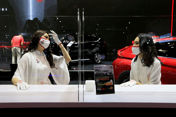 Satgas Covid 19 berpatroli mengelilingi booth pameran IIMS Hybrid 2021 mengingatkan pengunjung untuk selalu menerapkan prokes di Jakarta, Kamis (15/4/2021).