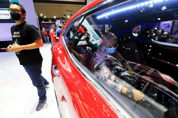 Pengunjung mengamati mobil yang dipamerkan pada ajang Indonesia International Motor Show (IIMS) Hybrid 2021 di JiExpo Kemayoran, Jakarta, Minggu (18/4/2021).