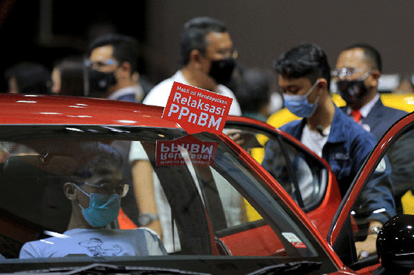 Pengunjung mengamati mobil yang dipamerkan pada ajang Indonesia International Motor Show (IIMS) Hybrid 2021 di JiExpo Kemayoran, Jakarta, Minggu (18/4/2021).