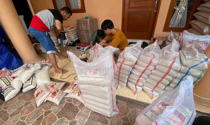 Pekerja mengemas beras di salah satu gudang di kawasan Jakarta Timur, Senin (19/4/2021).