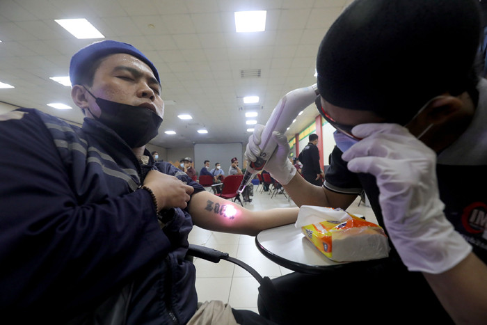 Peserta mengikuti pengahpusan tato secara gratis di Jakarta Islamic Centre (JIC), Jakarta, Selasa (20/4/2021).