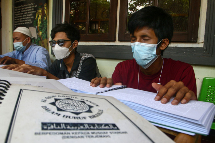 Sejumlah penyandang disabilitas dari Komunitas Mata Hati (KMH) Surabaya membaca Alquran Braile di markas KMH Surabaya, Jawa Timur, Selasa (20/4/2021).