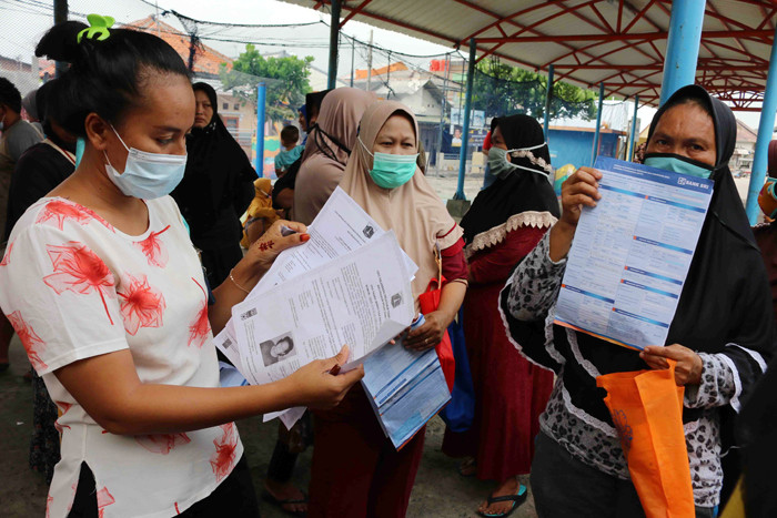 Warga antre untuk mencairkan dana bantuan UMKM di Dermaga Pelabuhan Pulau Panggang, Kepulauan Seribu Utara, Provinsi DKI Jakarta, Selasa (20/4/2021).