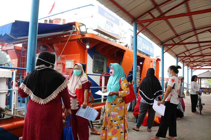 Warga antre untuk mencairkan dana bantuan UMKM di Dermaga Pelabuhan Pulau Panggang, Kepulauan Seribu Utara, Provinsi DKI Jakarta, Selasa (20/4/2021).
