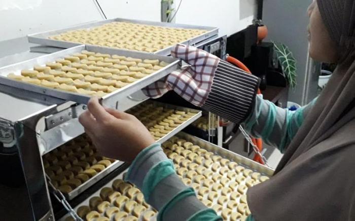 Rinna memanggang kue kering pesanan pelanggan.