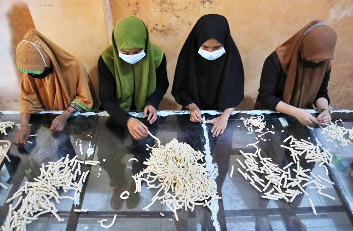 Sejumlah pekerja membuat Kue Otere (tali tali) di Makassar, Sulawesi Selatan, Rabu (21/4/2021).